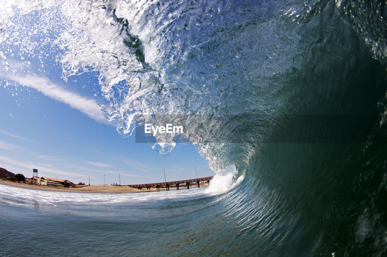 Waves flowing in sea against sky