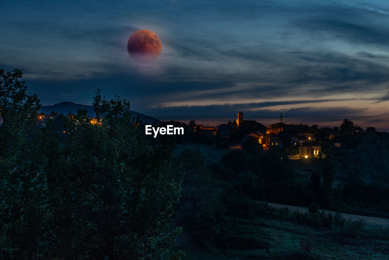 PANORAMIC VIEW OF BUILDINGS AGAINST SKY AT NIGHT