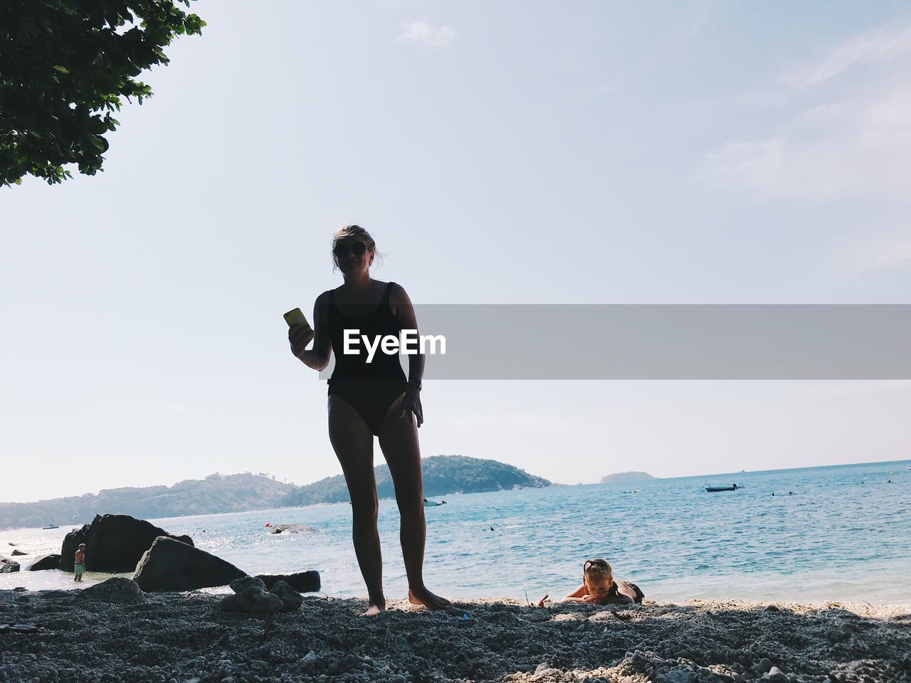 Rear view of woman and daughter on beach