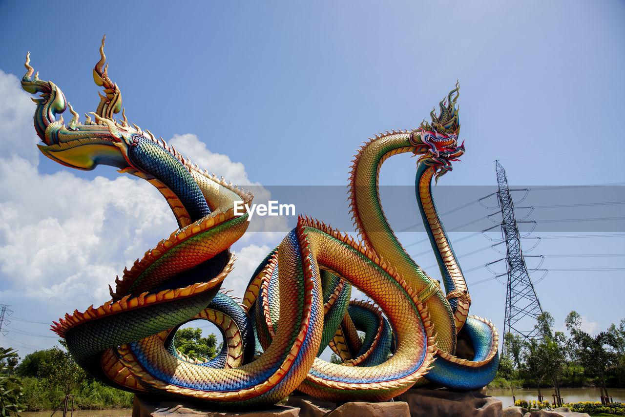  low angle twin stucco painted as a large serpent at pra kai keaw wang nakin,  udon thani, thailand.
