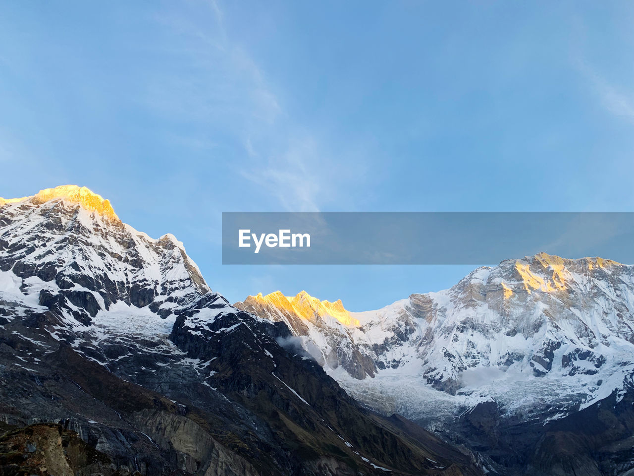 Scenic view of snowcapped mountains against sunrise