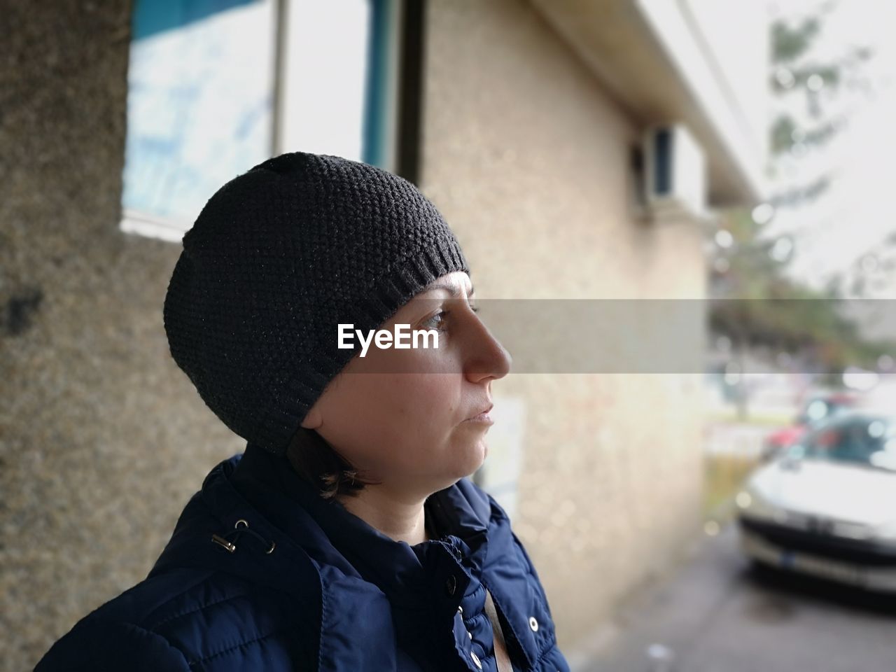 PORTRAIT OF MAN LOOKING AWAY IN CITY DURING WINTER