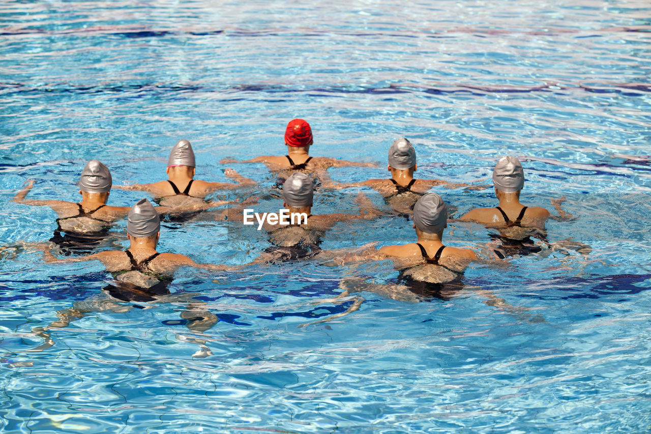 Rear view of women swimming in pool