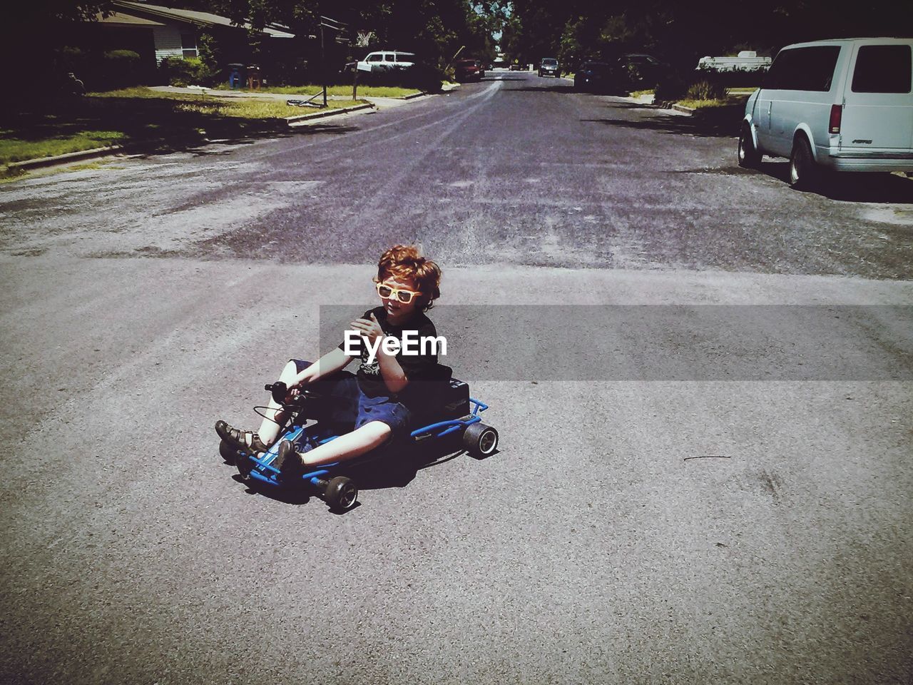 BOY SITTING IN CAR ON STREET