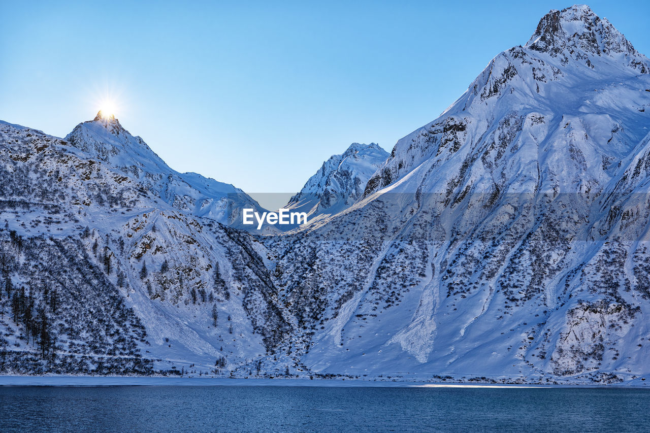 scenic view of snowcapped mountains against blue sky