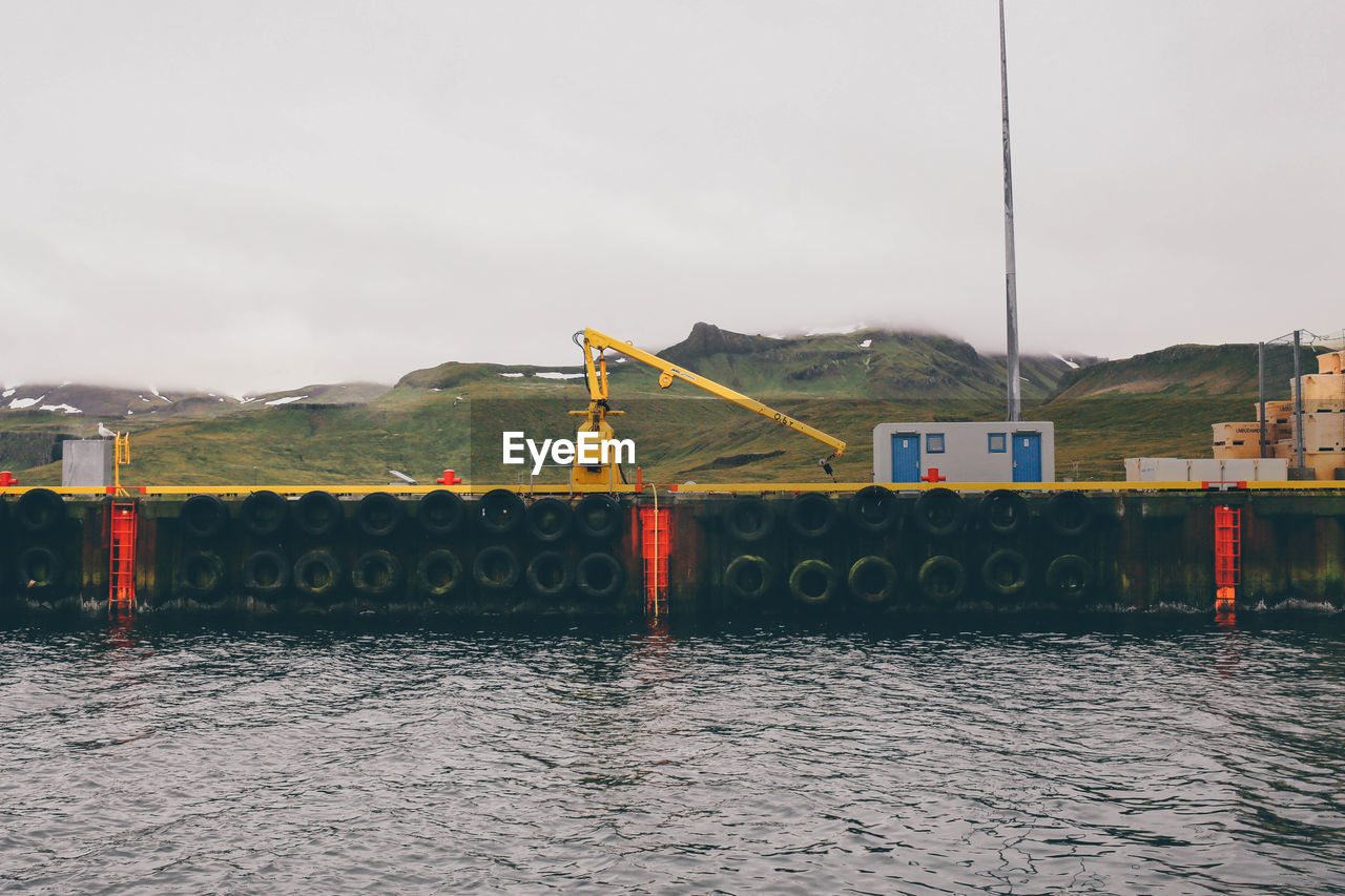 Commercial dock by river against mountains