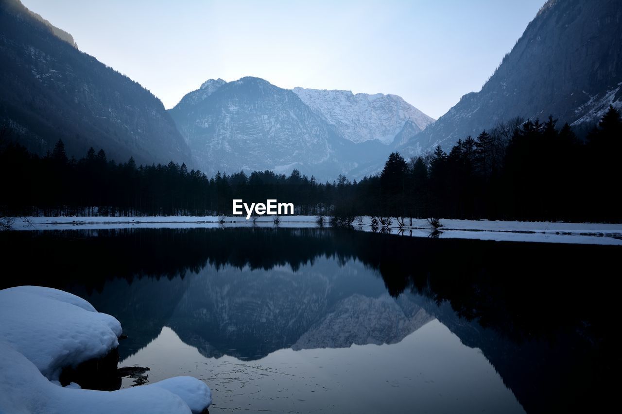 Scenic view of lake and snowcapped mountains against sky