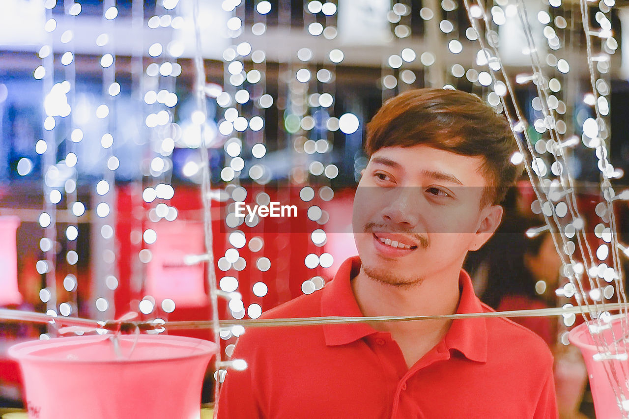 Smiling man seen through illuminated lights