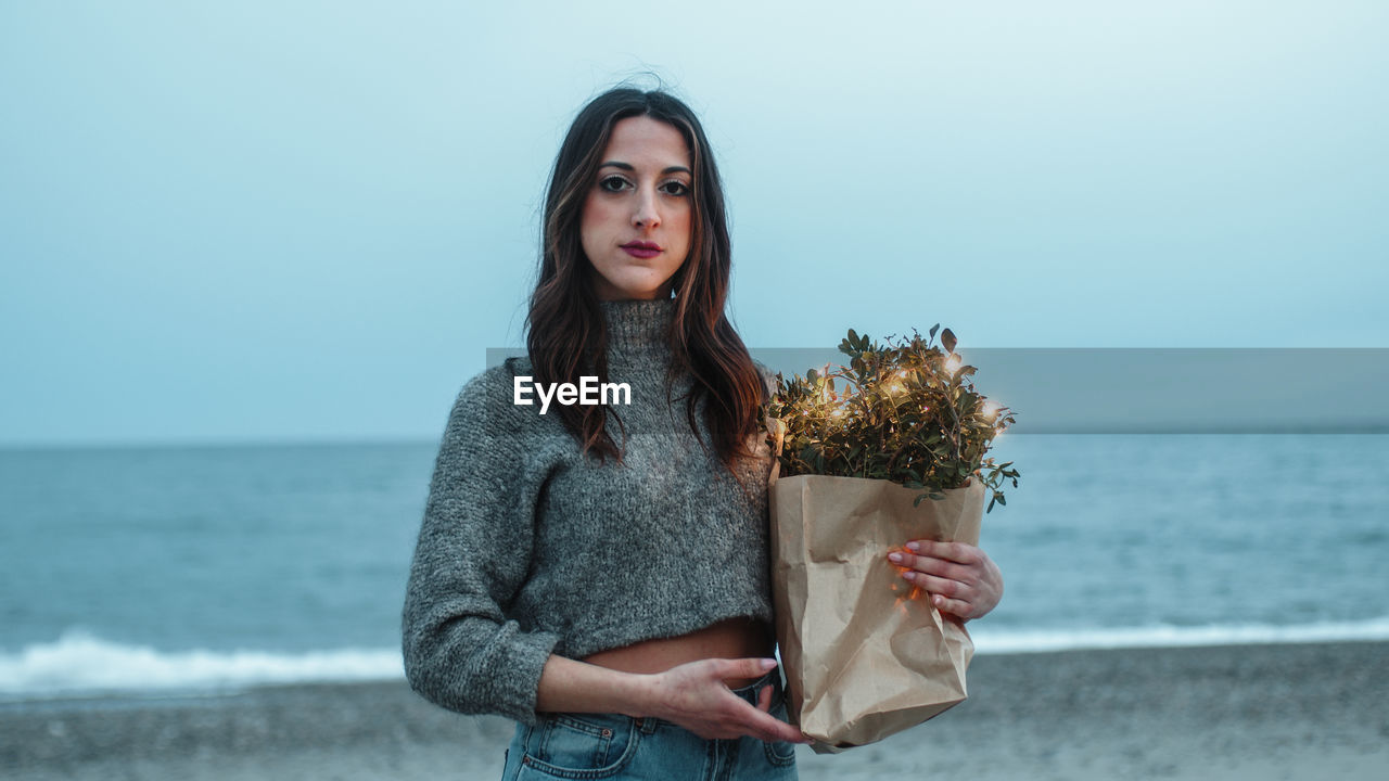 Girl on the beach with a shopping bag of lights