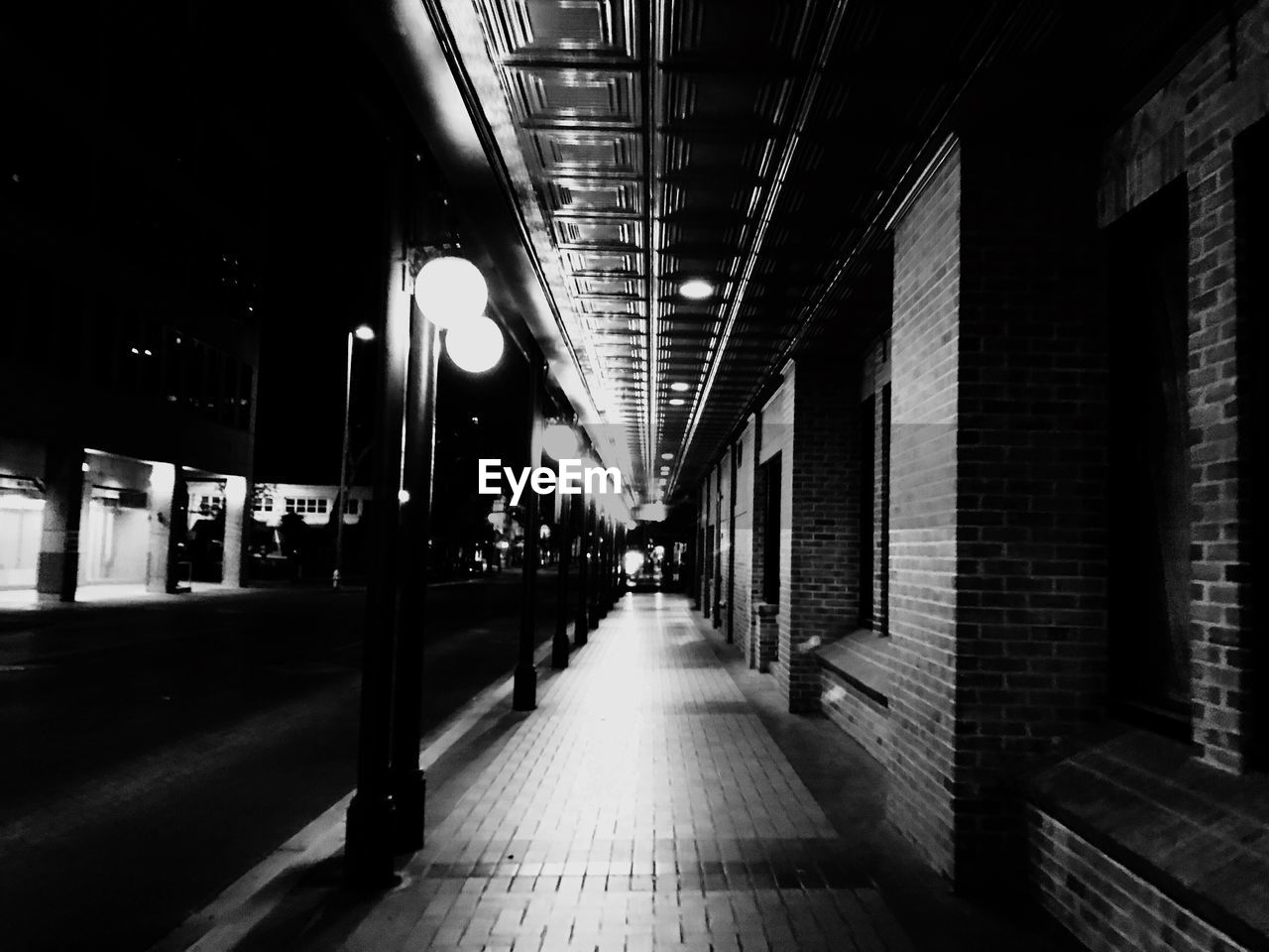 EMPTY CORRIDOR IN ILLUMINATED BUILDING