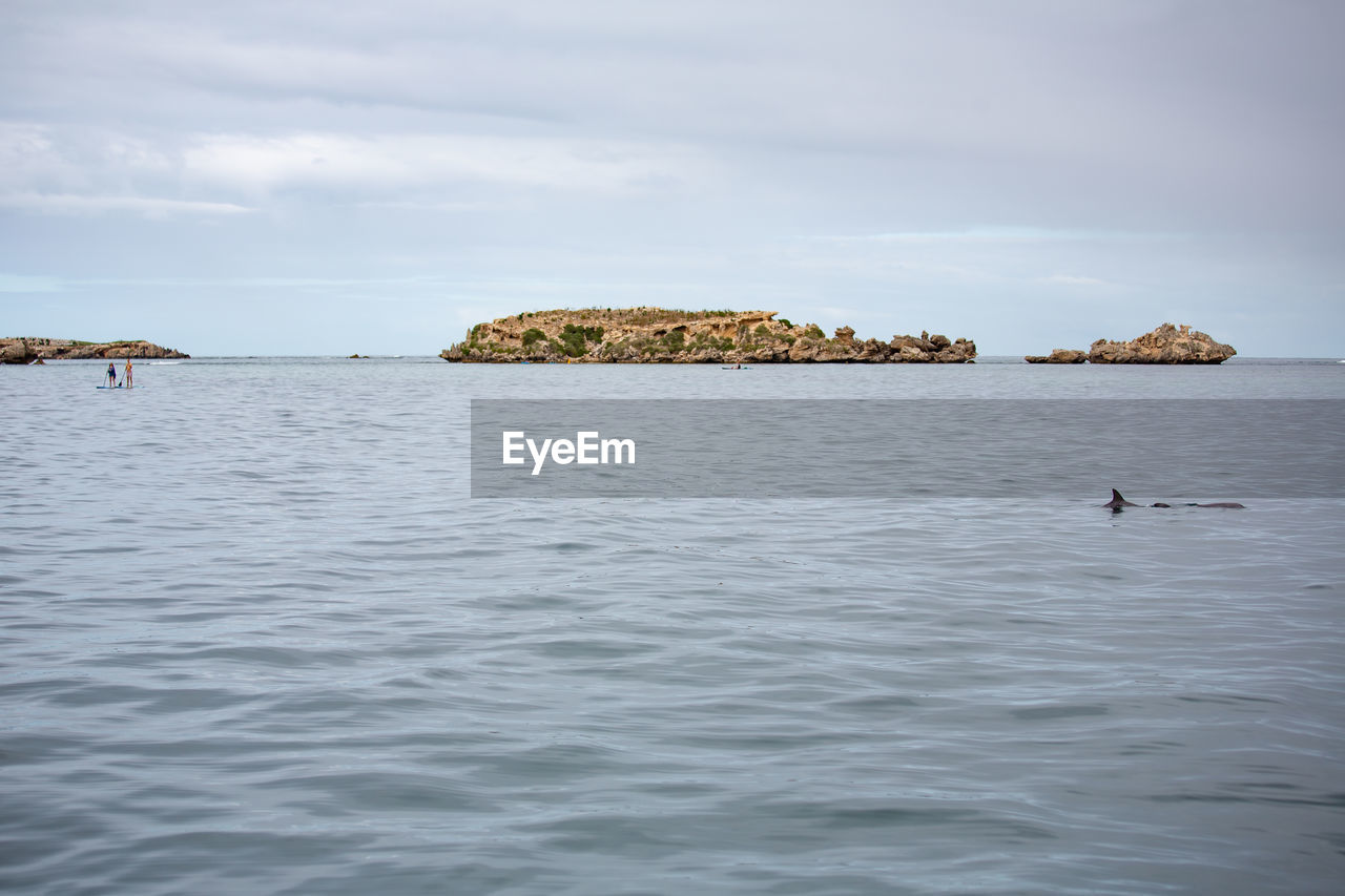 Scenic view of rocks in sea against sky