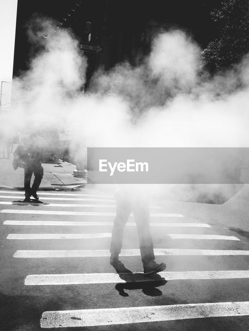 REAR VIEW OF PEOPLE WALKING ON ROAD IN CITY