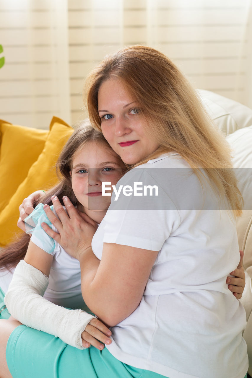 PORTRAIT OF HAPPY MOTHER AND DAUGHTER WITH BABY