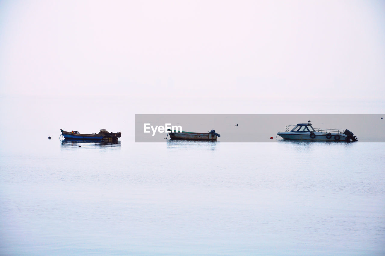 BOATS SAILING ON SEA AGAINST CLEAR SKY