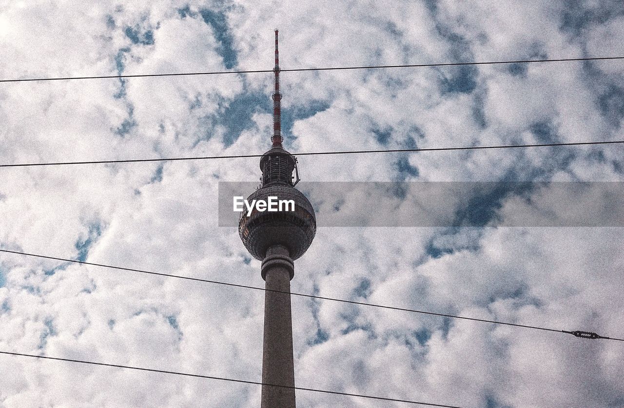 Low angle view of communications tower against sky in city