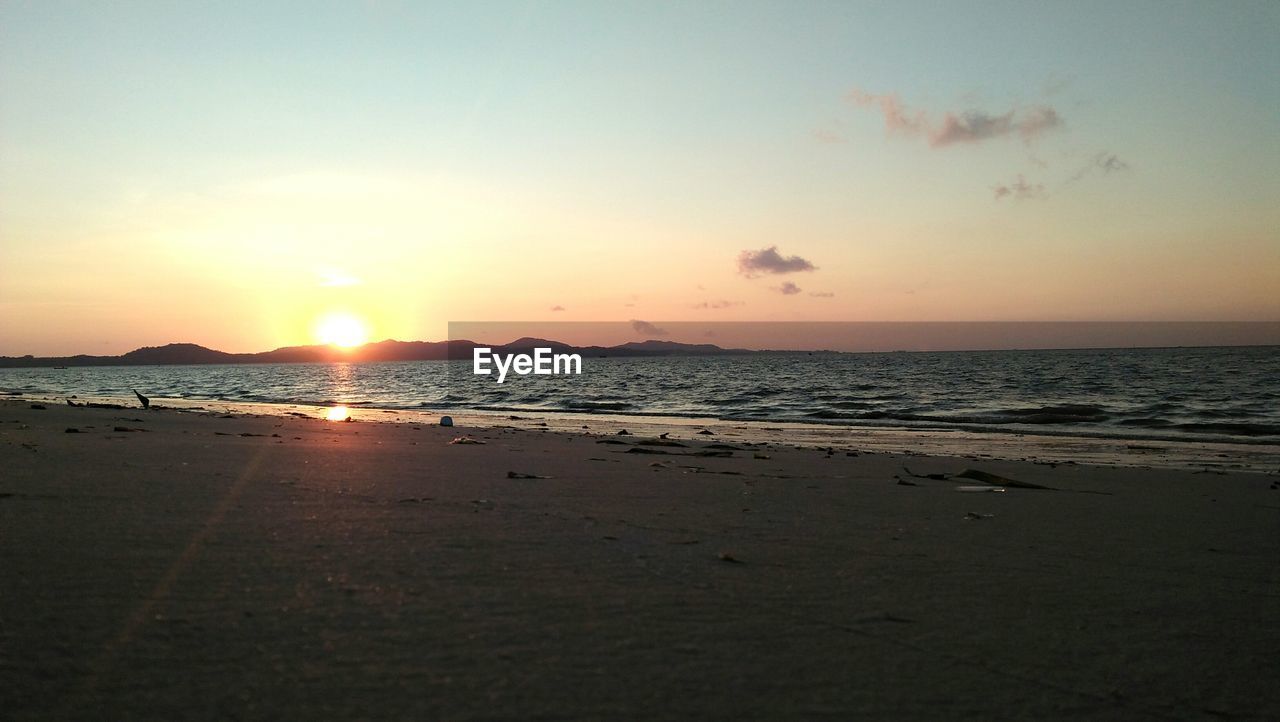 SCENIC VIEW OF BEACH DURING SUNSET