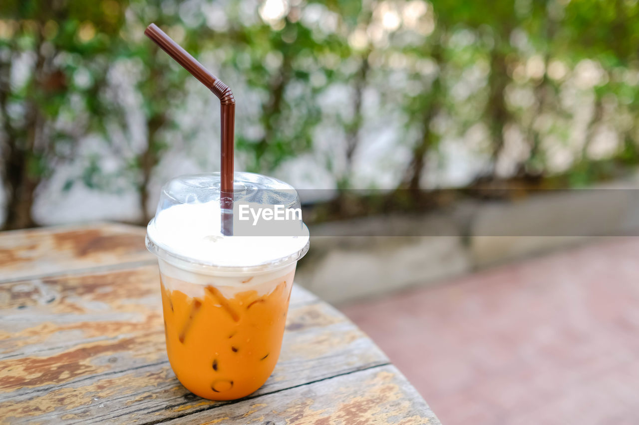 food and drink, drink, refreshment, soft drink, drinking straw, focus on foreground, food, household equipment, straw, drinking glass, wood, table, no people, glass, day, outdoors, freshness, produce, close-up, nature, cup, healthy eating, wellbeing