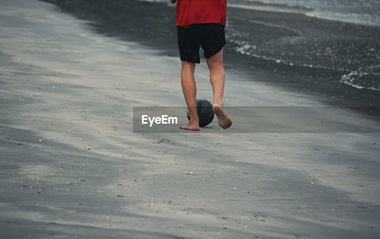 one person, sports, motion, lifestyles, leisure activity, human leg, person, land, day, nature, running, rear view, low section, adult, beach, clothing, exercising, men, sand, shoe, shorts, footwear, vitality, casual clothing, outdoors, water, walking, wet, winter, barefoot, jogging, full length, athlete