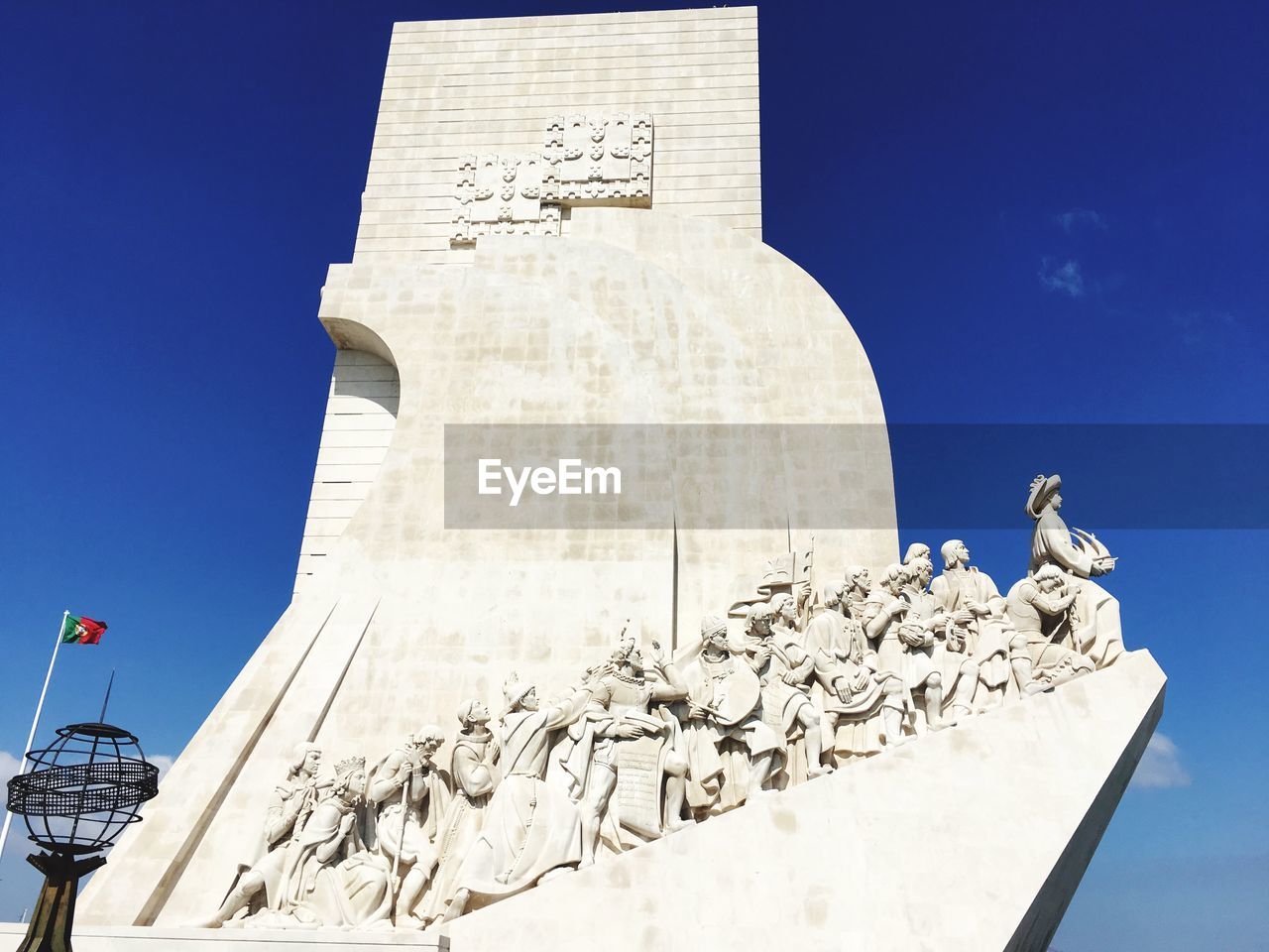 LOW ANGLE VIEW OF CROSS STATUE AGAINST BUILDING