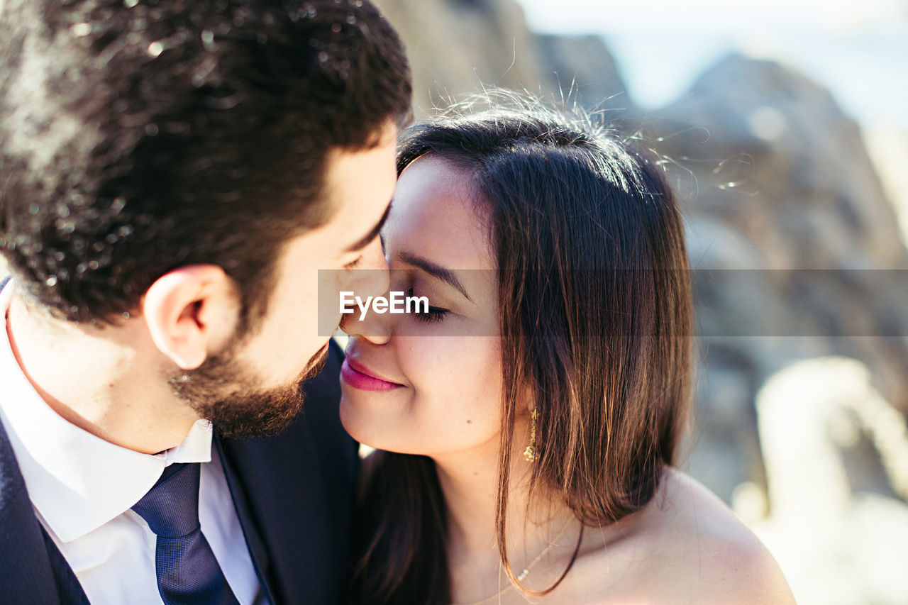 Close-up of newlywed couple romancing at beach