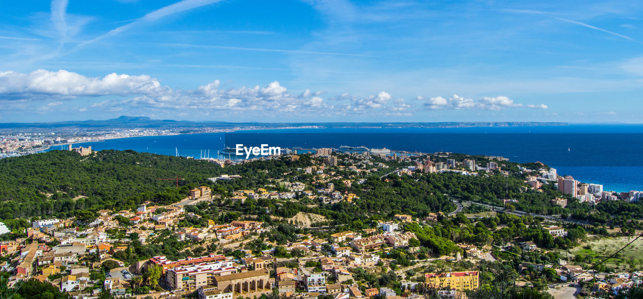 High angle view of town by sea against sky