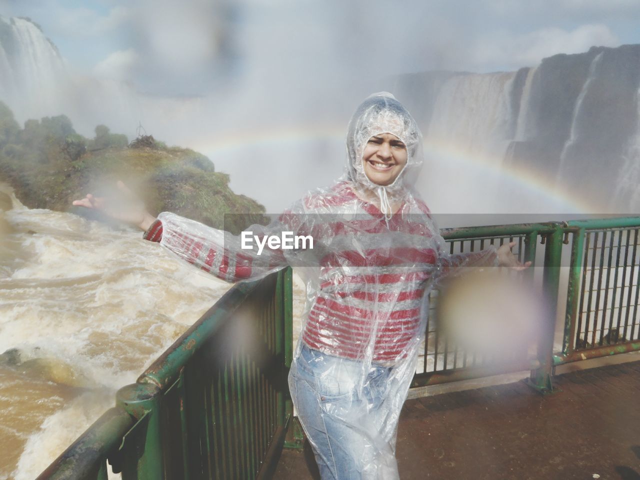 Portrait of female tourist wearing raincoat at iguacu falls