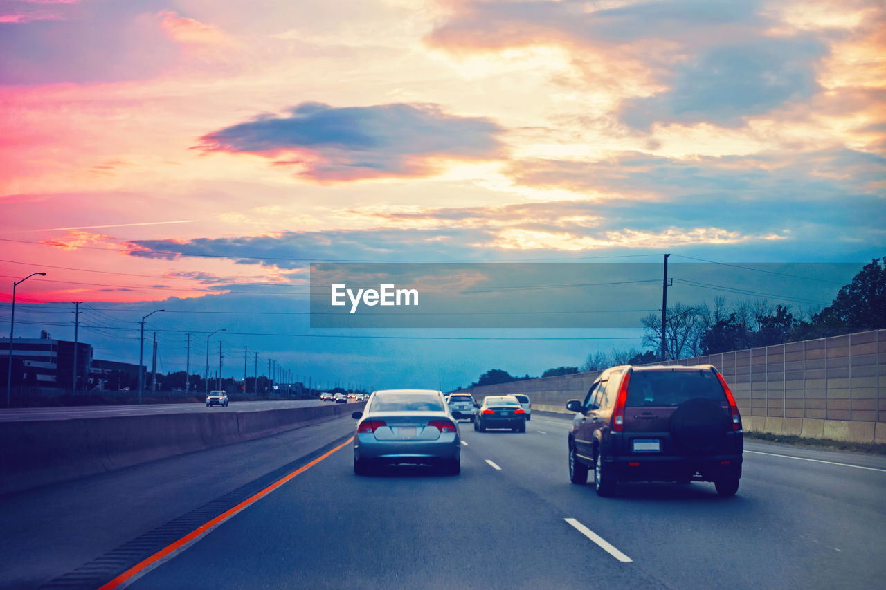 CARS ON ROAD AT SUNSET