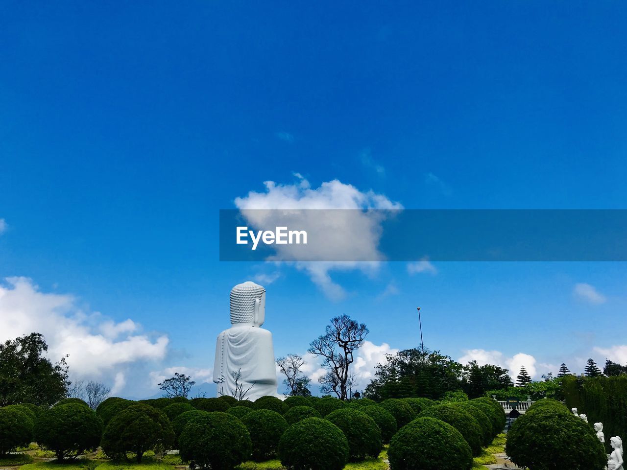 STATUE AGAINST BLUE SKY AND TREES