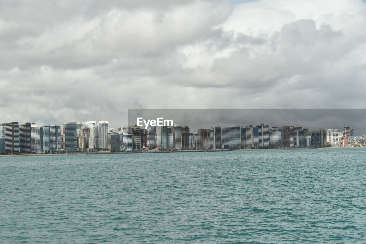 Sea and cityscape against sky