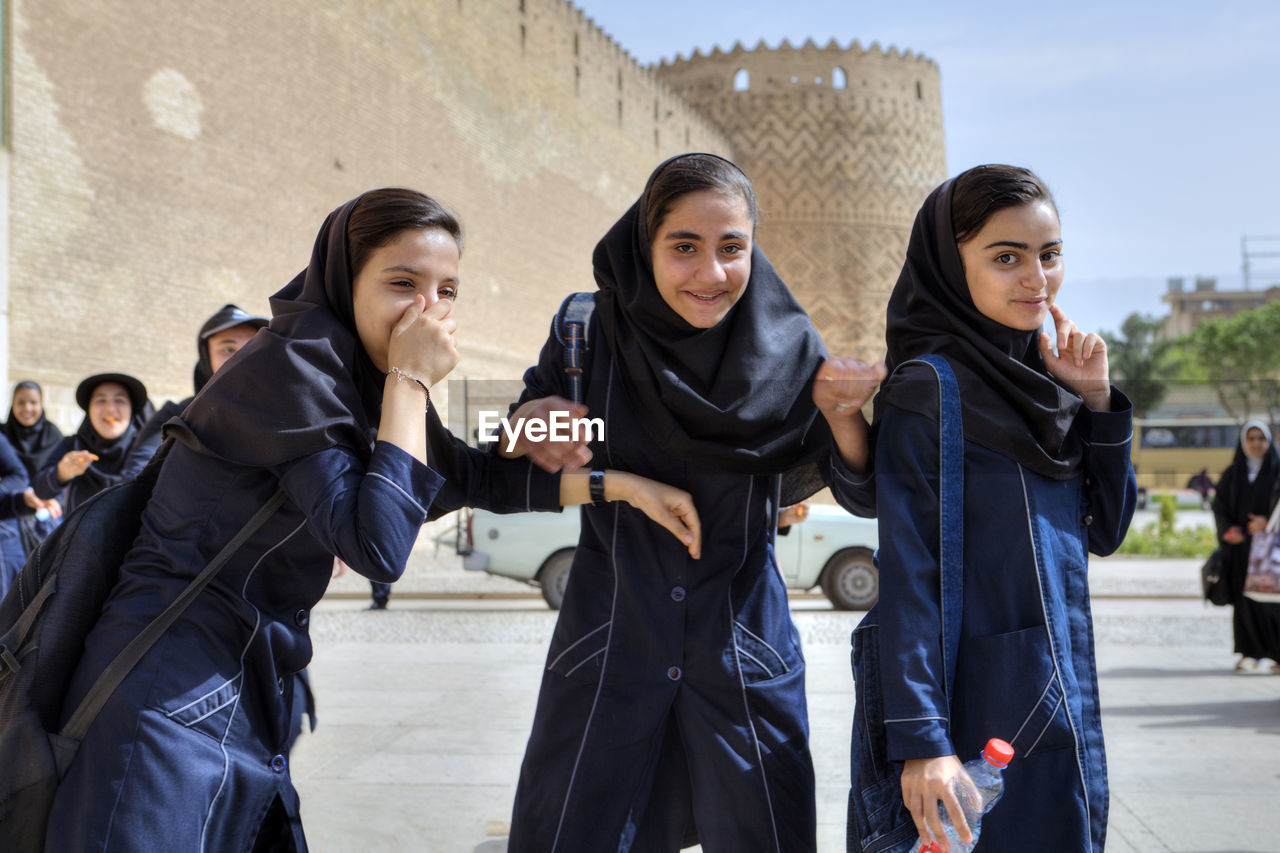 WOMEN STANDING AGAINST THE SKY