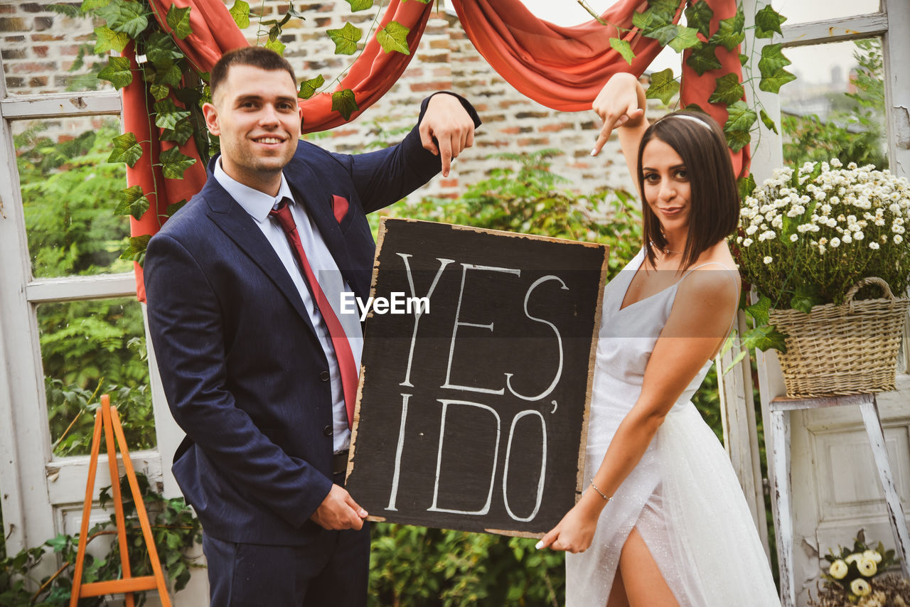 Portrait of couple standing outdoors during wedding ceremony 