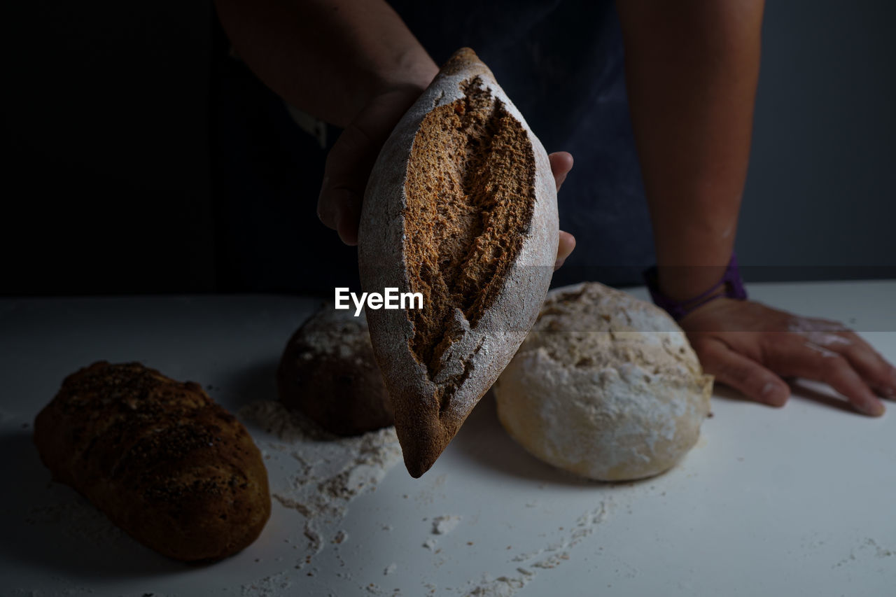 Close-up of hand holding bread on table