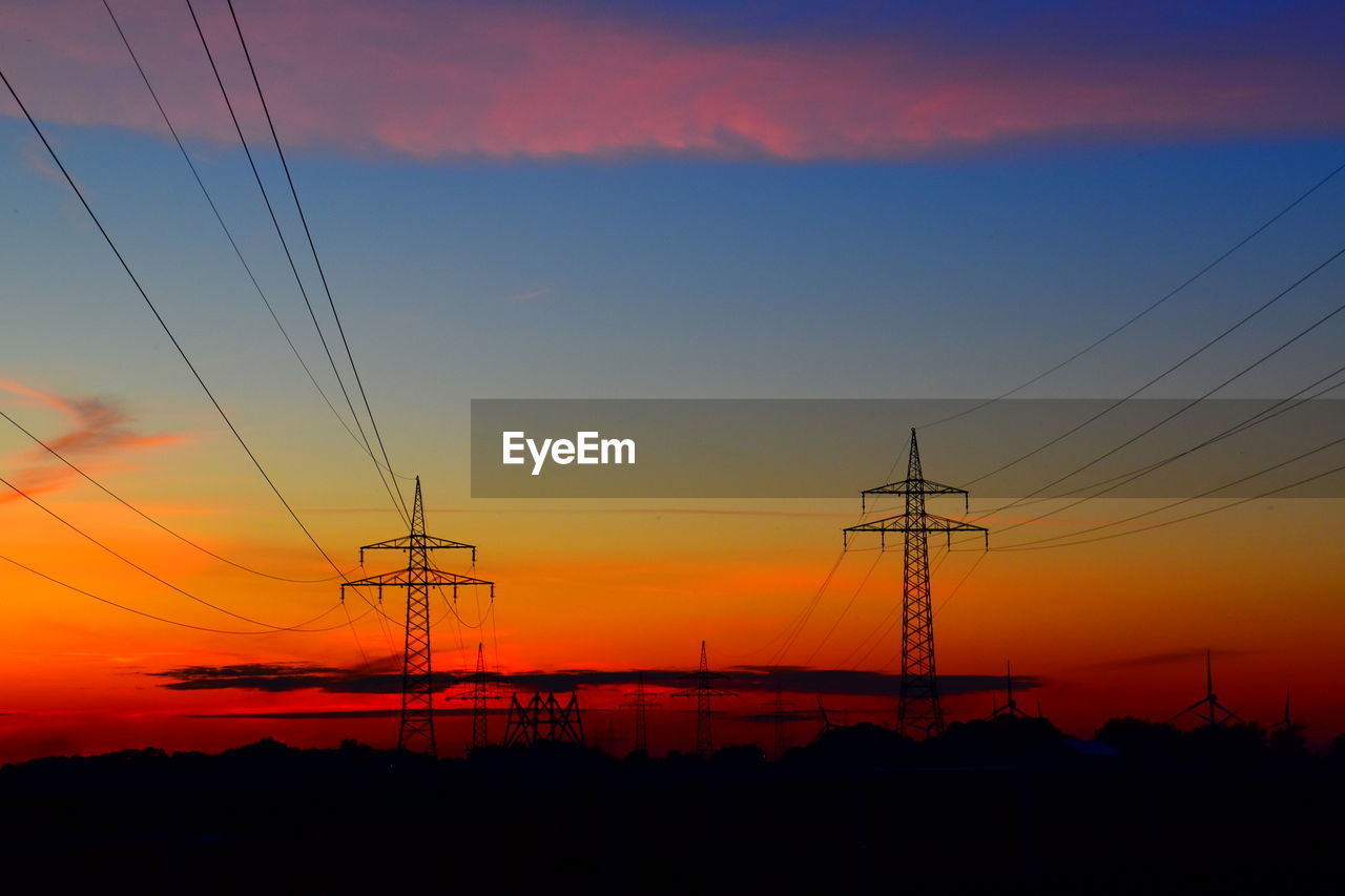 SILHOUETTE ELECTRICITY PYLONS AGAINST SKY DURING SUNSET