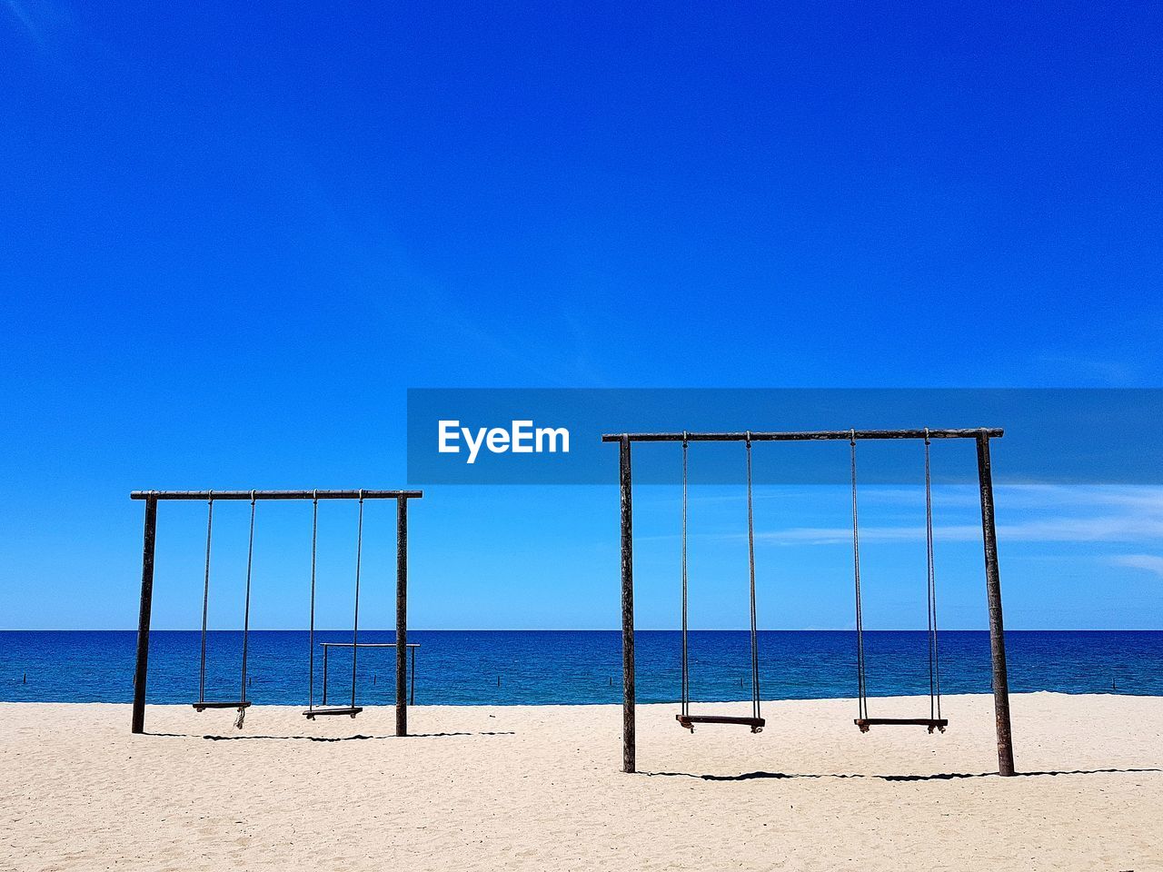 Scenic view of beach against clear blue sky