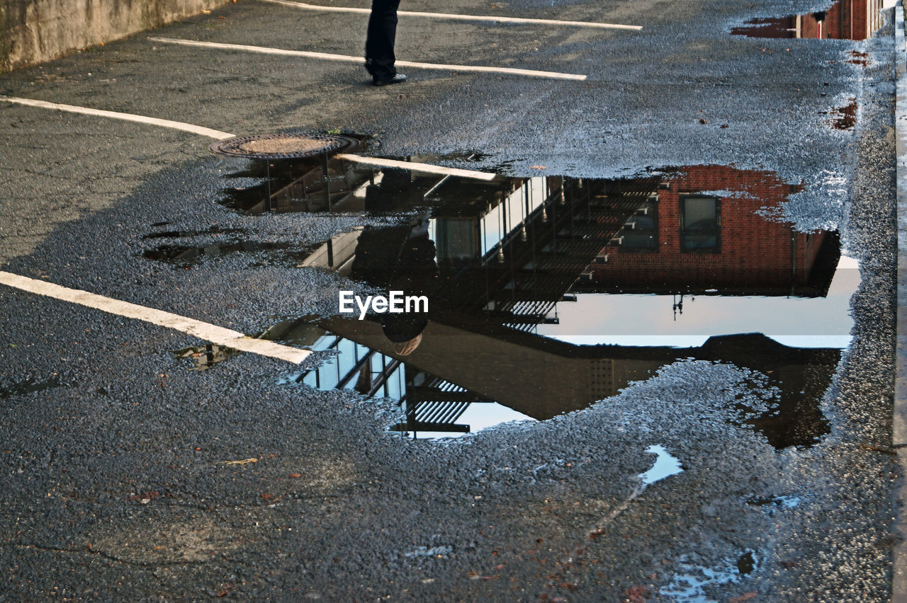 Puddle with reflection of building on road