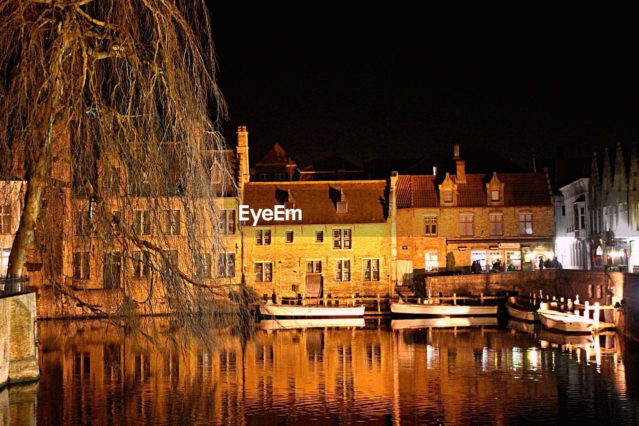 ILLUMINATED BUILDINGS WITH WATERFRONT AT NIGHT