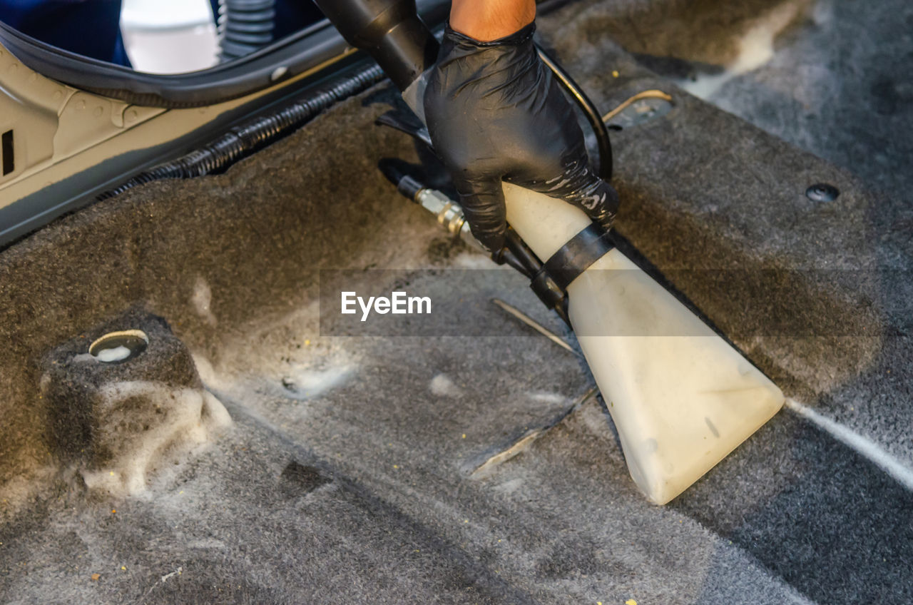 Cropped hand of man cleaning car in garage