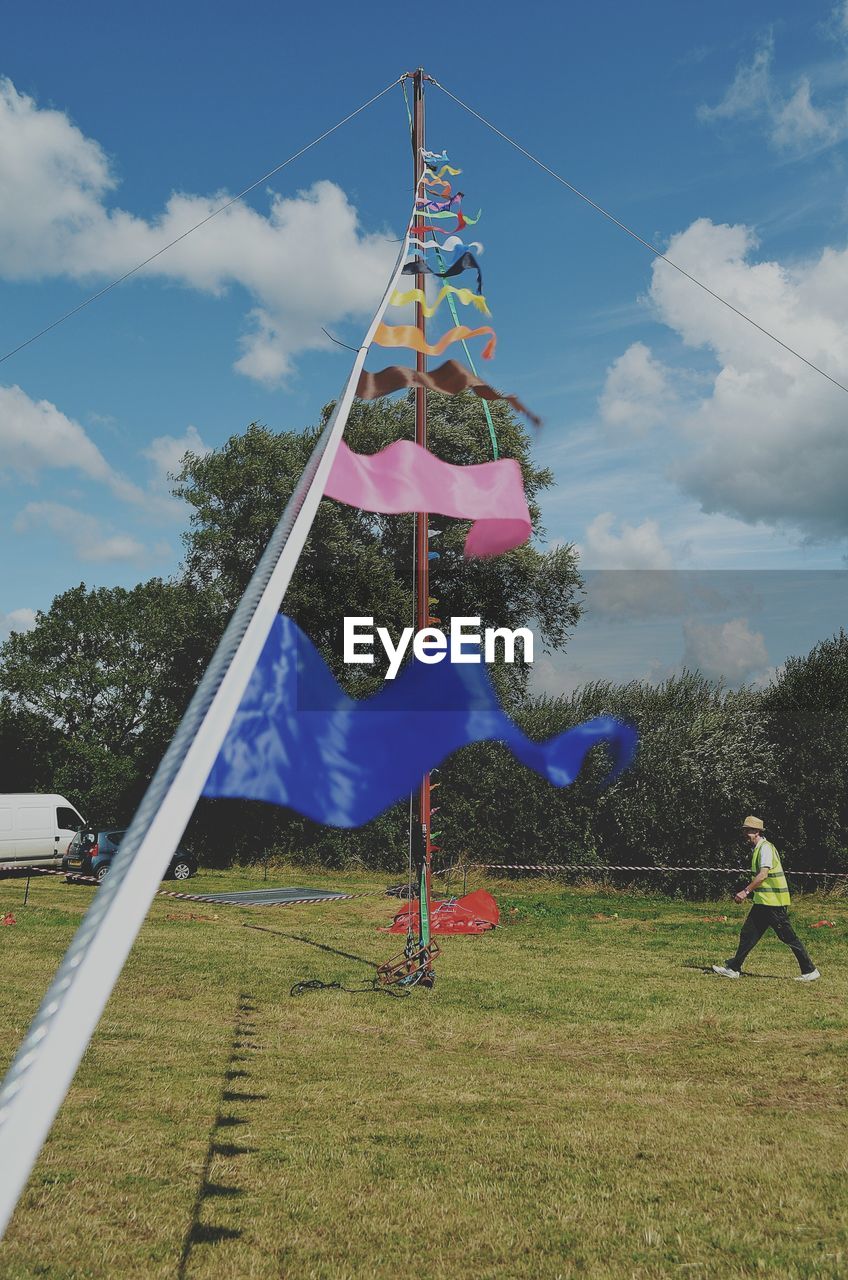 CLOTHES FLAGS ON GRASS AGAINST SKY