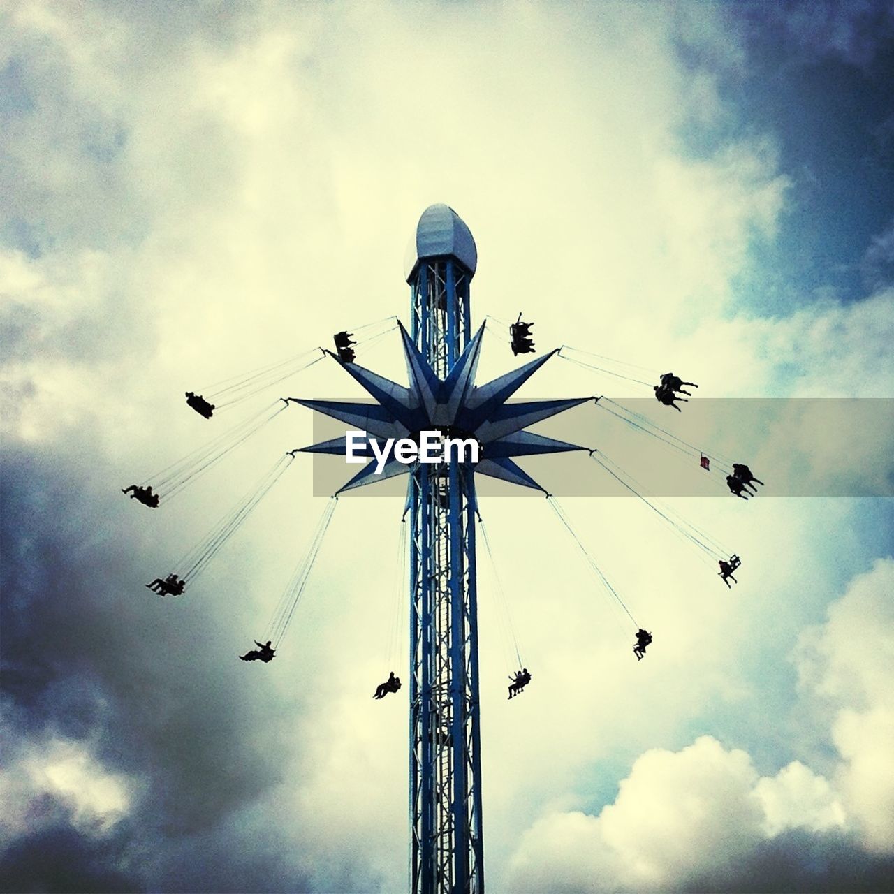 LOW ANGLE VIEW OF FERRIS WHEEL AND FERRIS WHEEL AGAINST CLOUDY SKY