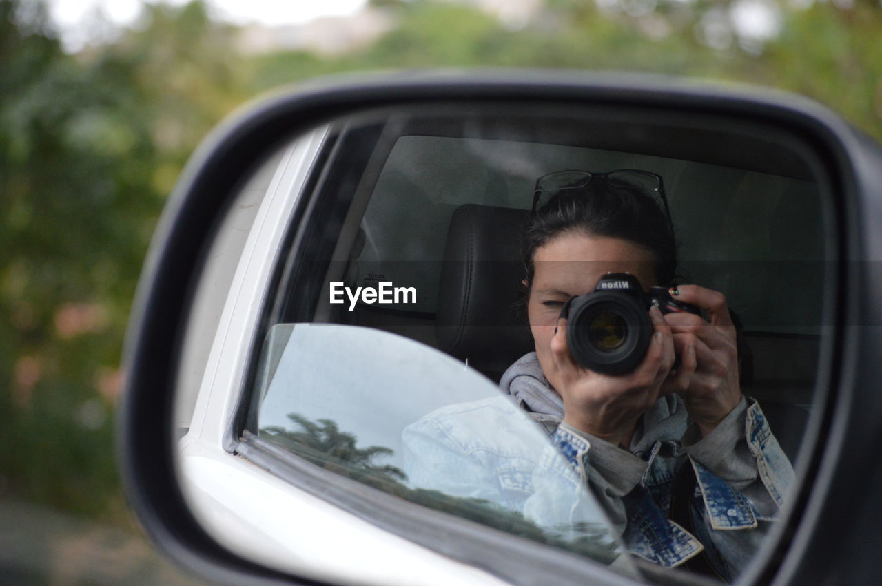 CLOSE-UP OF YOUNG WOMAN TAKING SELFIE