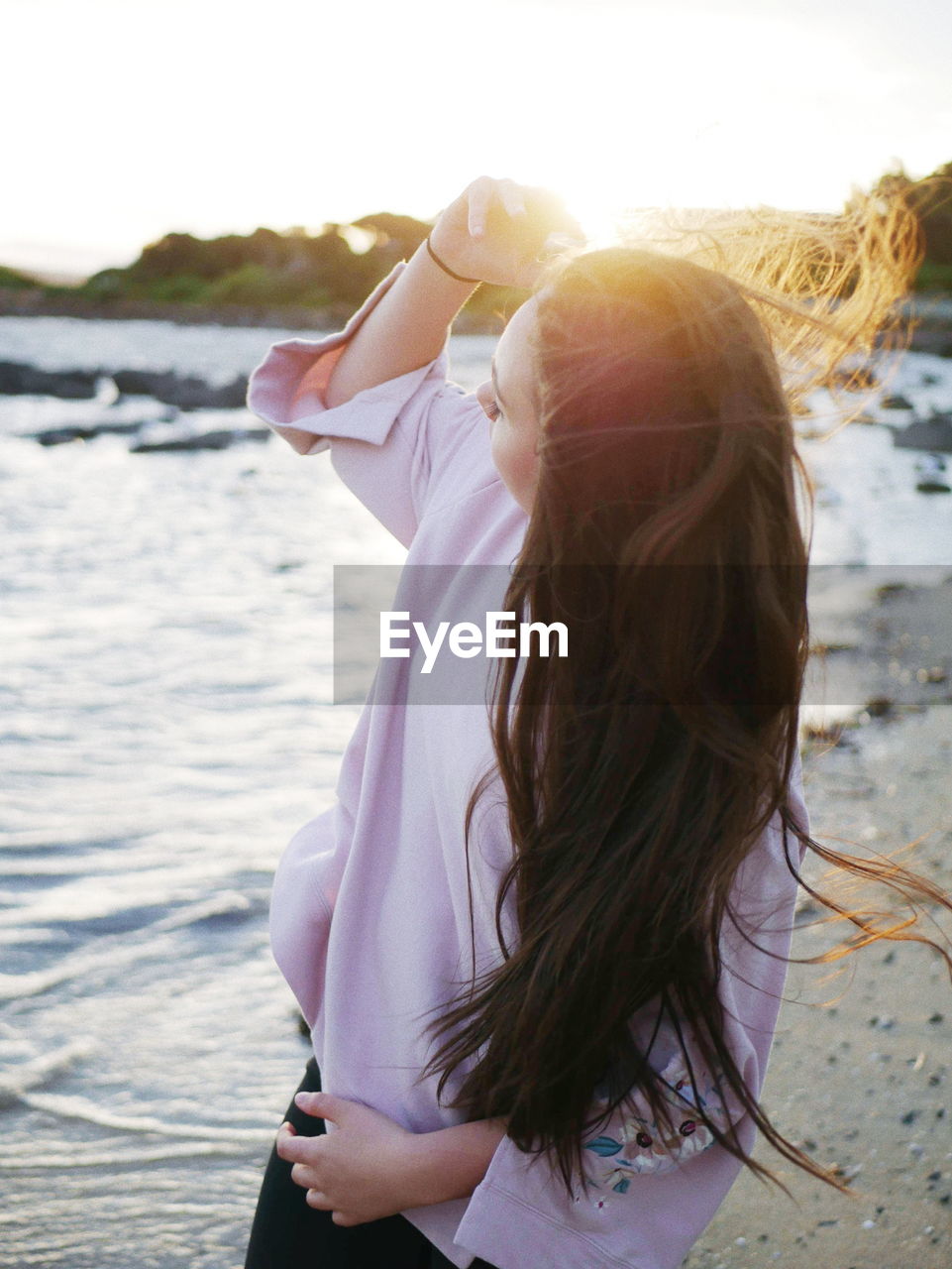 Woman standing at beach during sunset