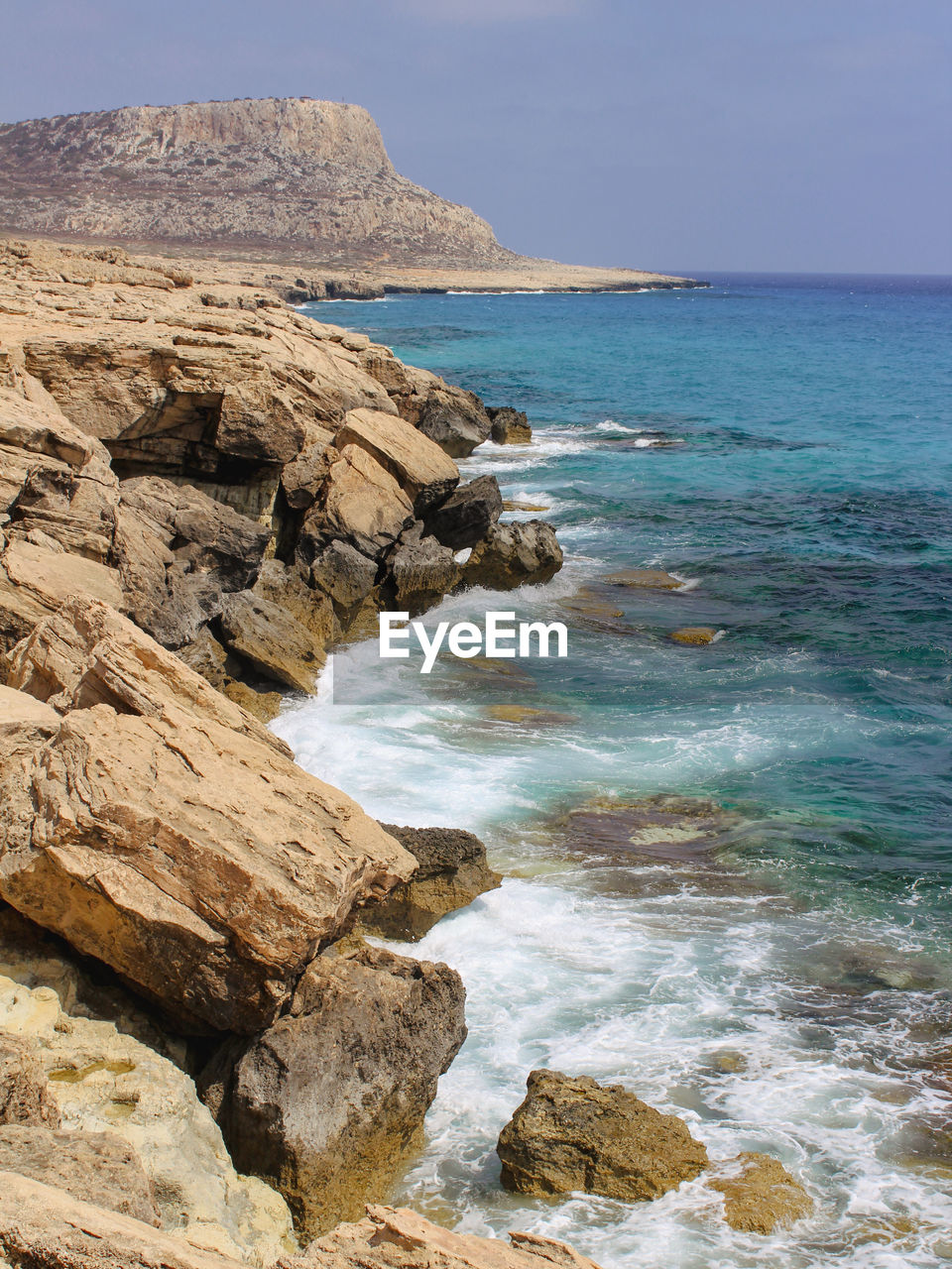 sea, water, land, rock, scenics - nature, beauty in nature, beach, sky, shore, nature, body of water, ocean, coast, cliff, travel destinations, tranquility, rock formation, no people, wave, tranquil scene, travel, terrain, horizon, day, environment, coastline, cove, horizon over water, outdoors, landscape, vacation, idyllic, non-urban scene, motion, tourism, blue, sports, bay, sand