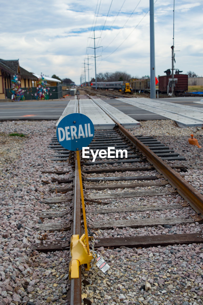 TEXT ON RAILROAD TRACK AGAINST SKY