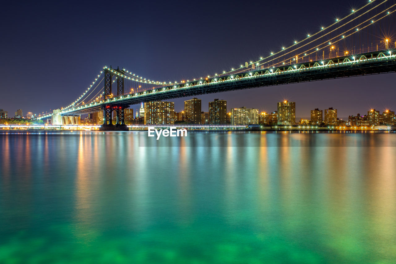 Illuminated manhattan bridge over east river at night