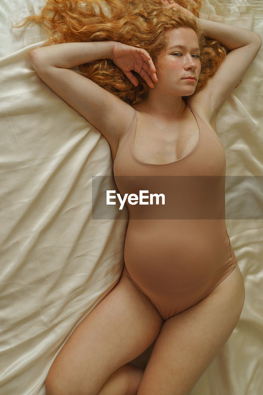 High angle view of pregnant  woman lying in bed