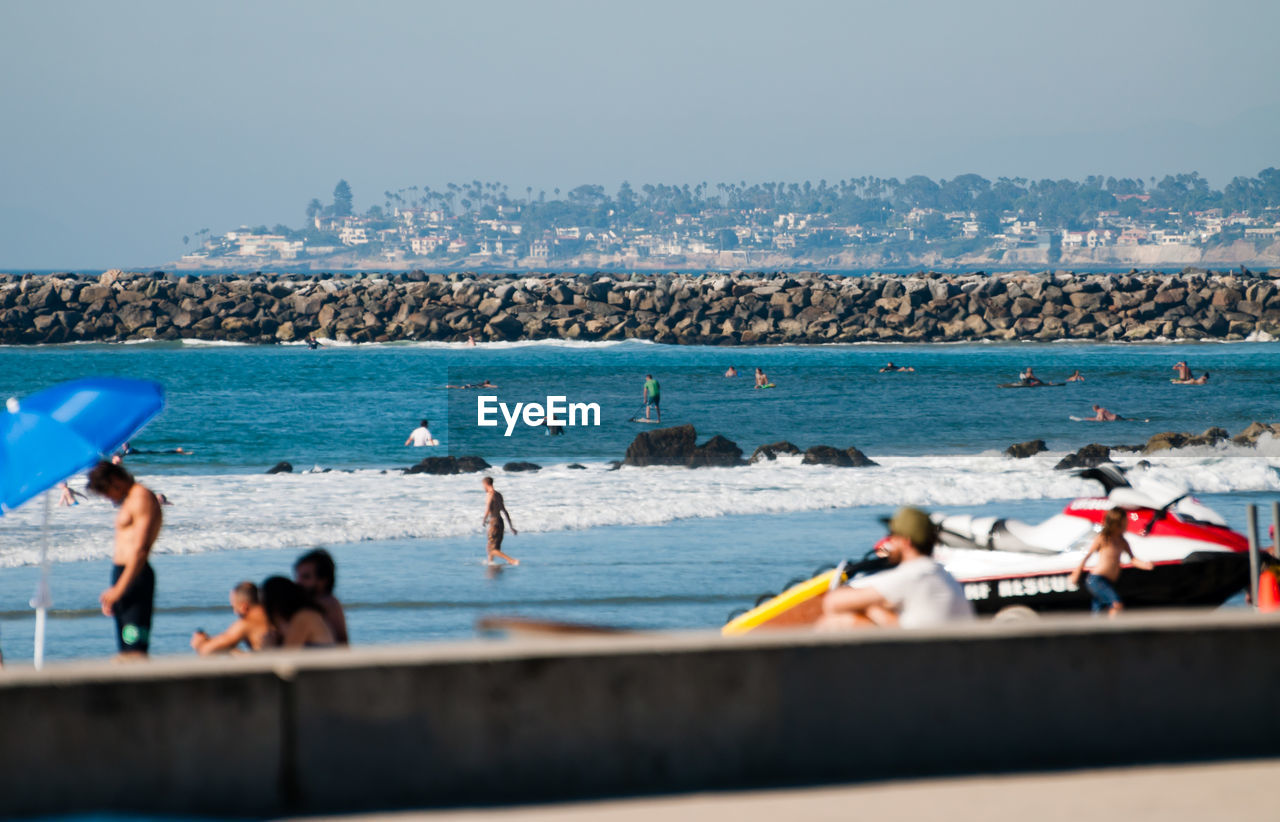 People at beach against clear sky