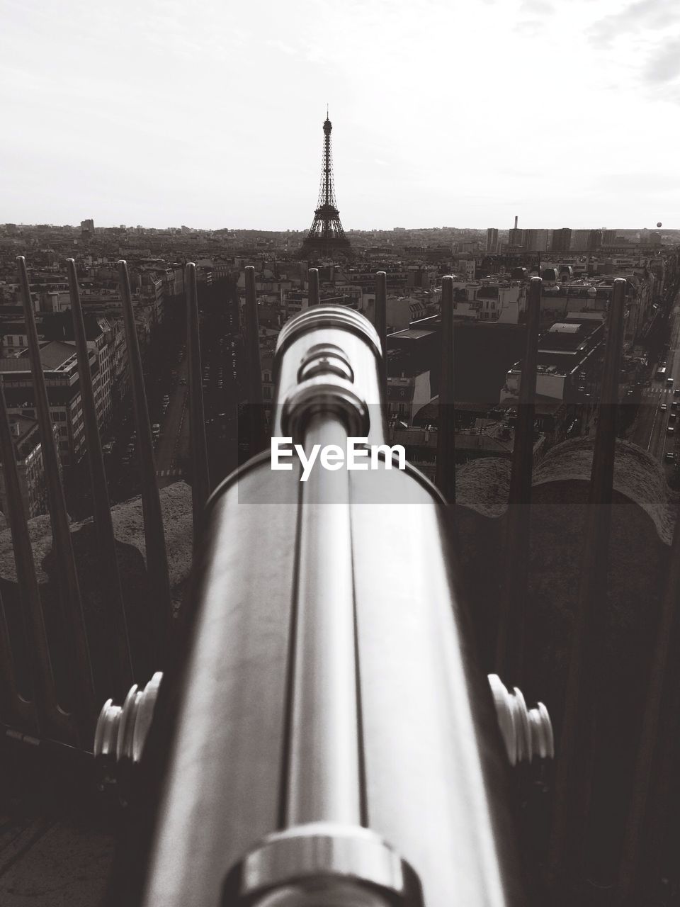 Cityscape with eiffel tower and coin operated binoculars in foreground