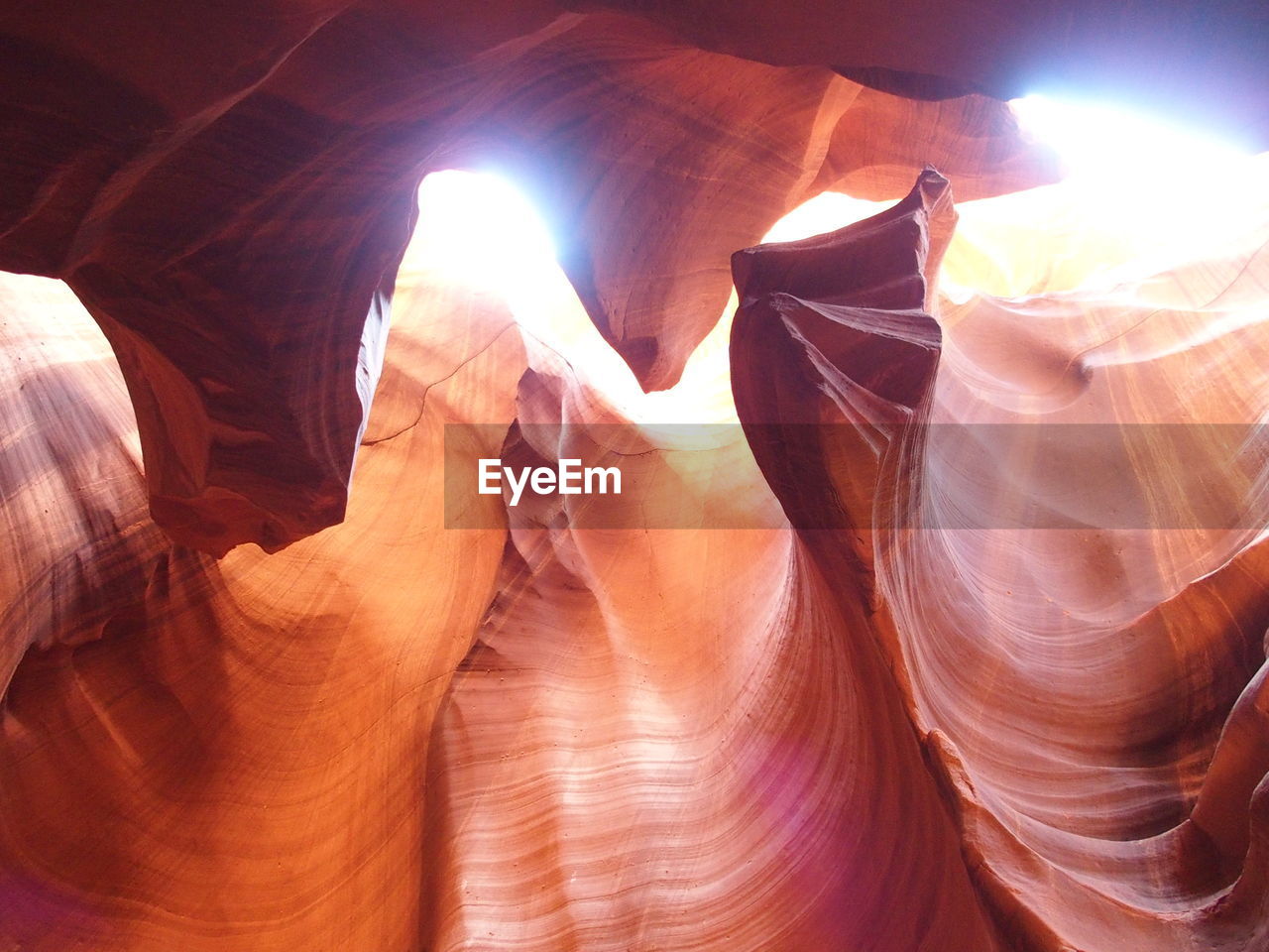 LOW ANGLE VIEW OF SUN STREAMING THROUGH ROCKS