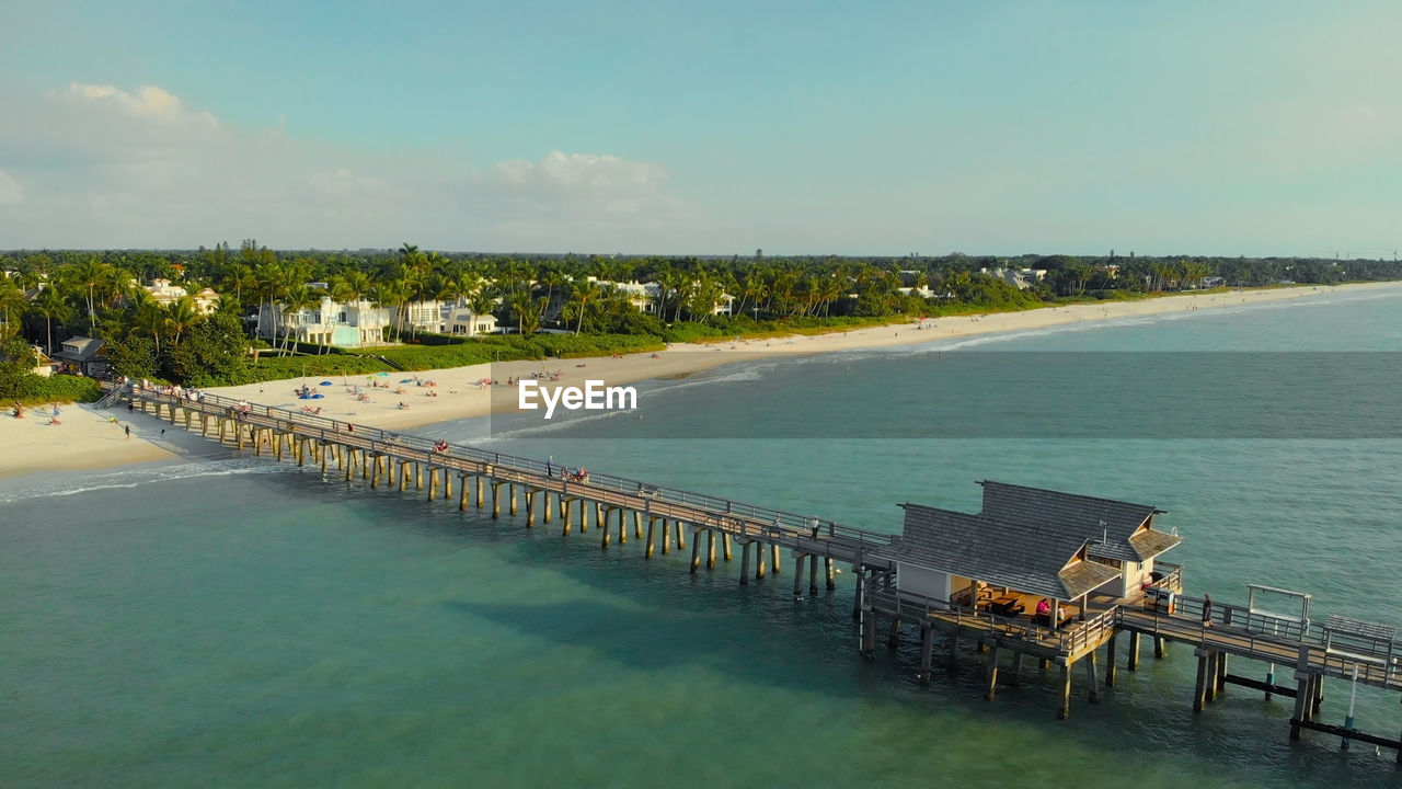 Pier in naples by aerial drone. drone flies around a fishing pier in naples. naples beach pier.