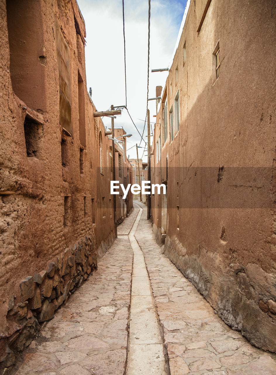 Alley amidst buildings against sky